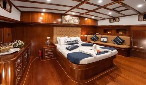 Interior view of Estrella De Mar master cabin with wooden panels and large bed