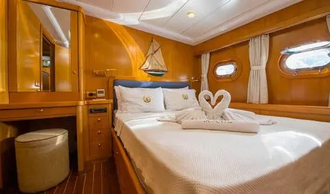 Master cabin with king bed, white linens, wood paneling, ensuite hints