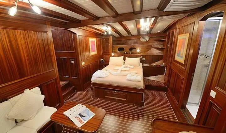 Interior cabin on Zephyria II yacht with wooden walls and bed