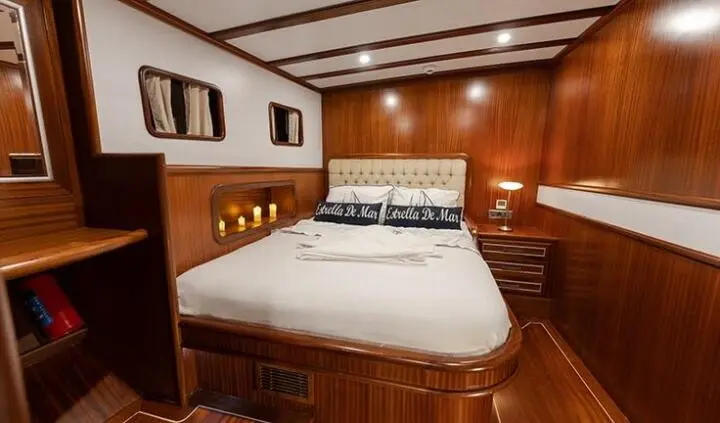 Estrella De Mar yacht cabin with large bed, wood paneling, and built-in storage