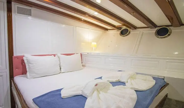 Cozy yacht cabin with two twin beds arranged side by side and white linens