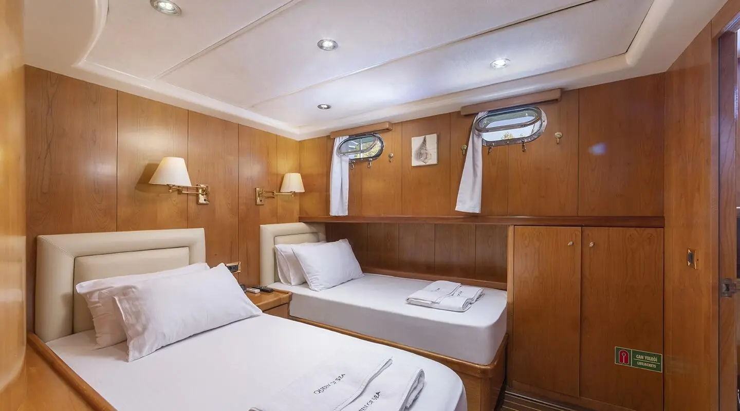 Queen Of Sea luxury gulet interior with two single beds and wooden paneling