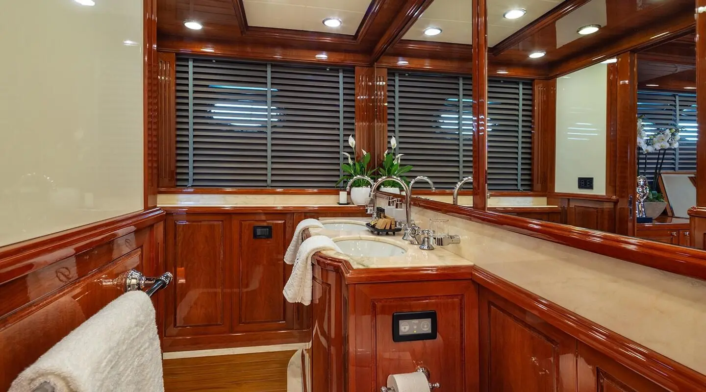 Luxurious yacht bathroom on Divine with polished wood cabinets and sink area