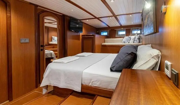 Master cabin with king bed, wood walls, and built-in cabinets on Bodrum Queen