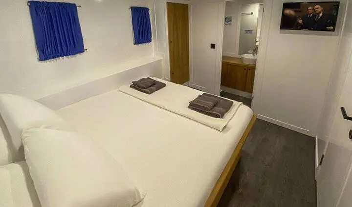 Maske 5 master cabin with king bed and two pillows on white bedding