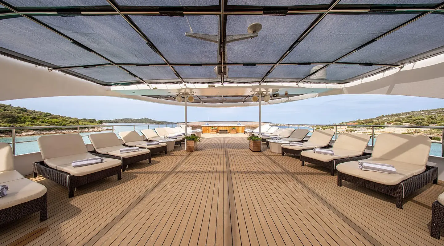 View along the Karizma yacht deck at sunset with sun loungers aboard