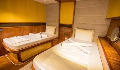 Nevra Queen yacht cabin with two single beds and neutral beige décor