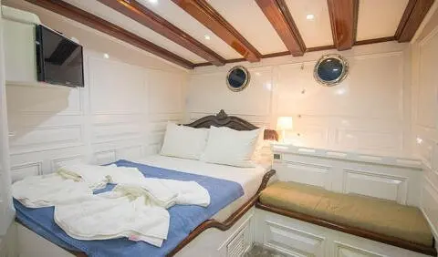 Grande Mare yacht cabin with king bed, white linens, wood ceiling beams