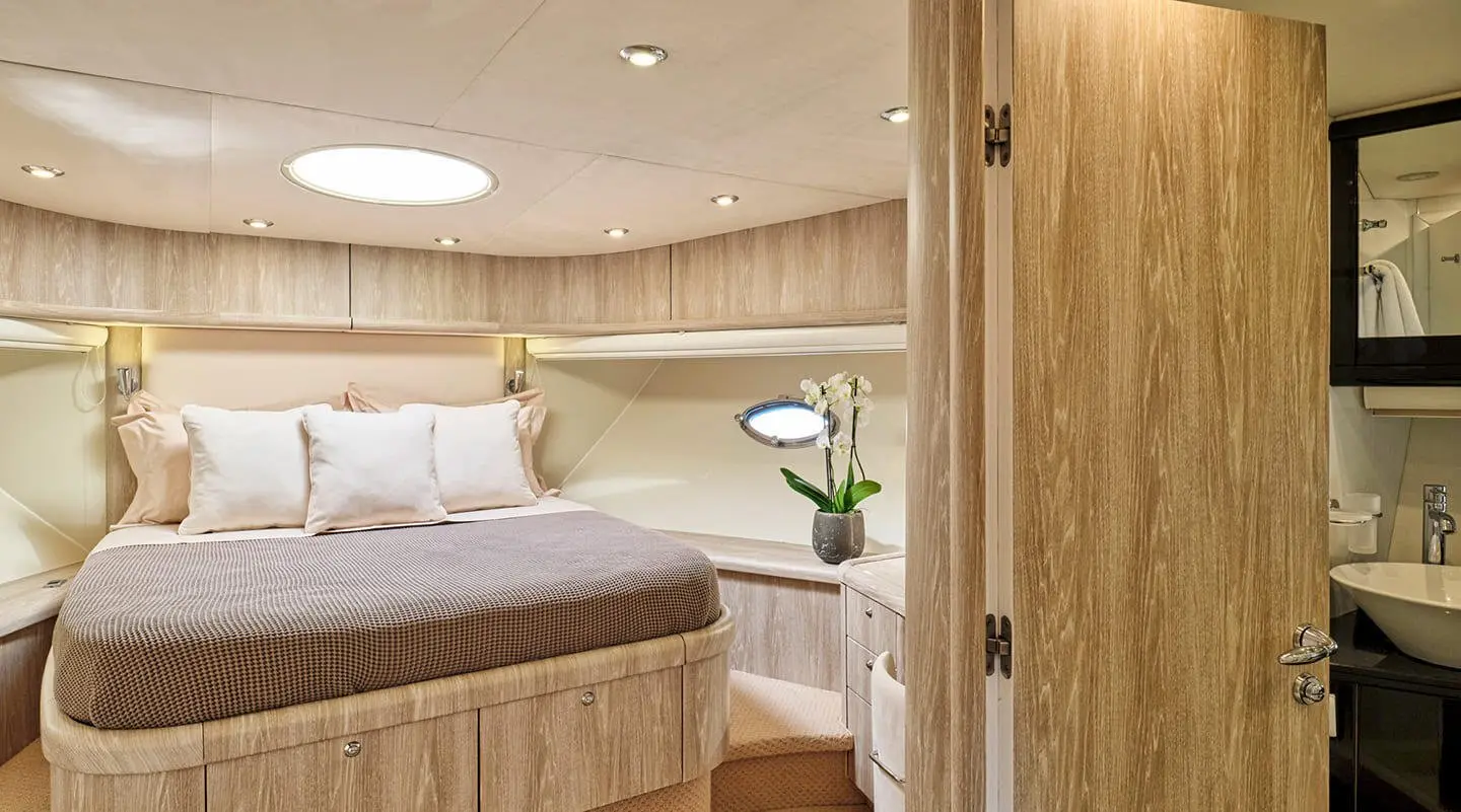 Yacht M Five interior cabin with bed, wood paneling, and seating area