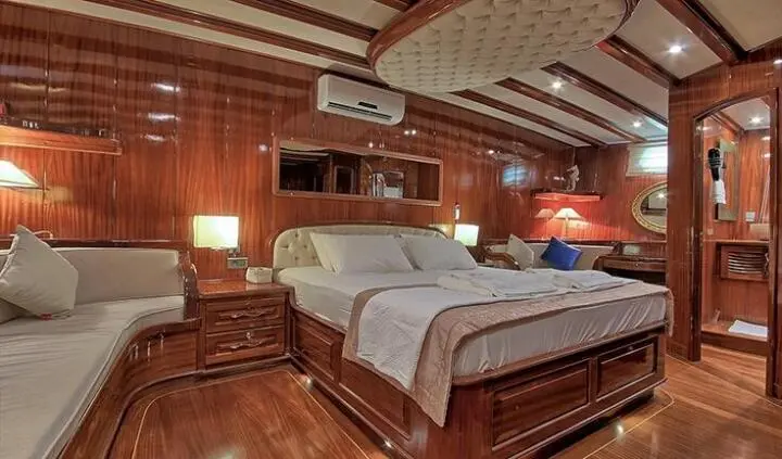 Lycian Queen master cabin with king bed, wood paneling, built‑in shelves