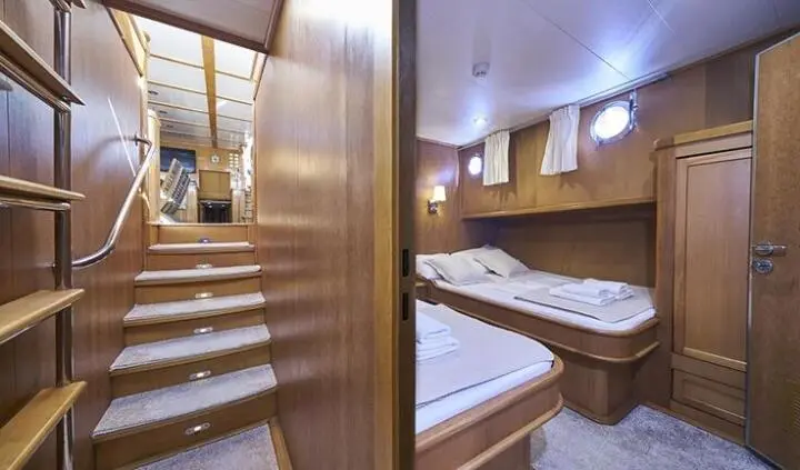 Morning Star cabin berth: two single beds, wood panels, portholes, compact interior