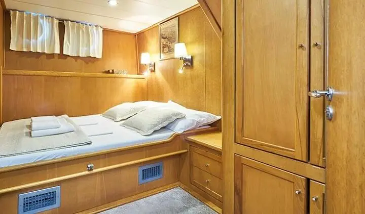 Master cabin with a single bed, wood paneling, and built-in wardrobe