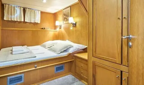 Master cabin with a single bed, wood paneling, and built-in wardrobe