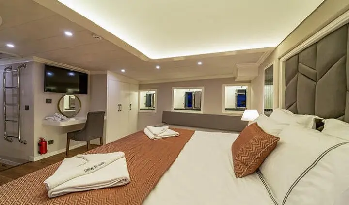 Queen Of Makri cabin bed with ensuite visible in a luxurious yacht interior