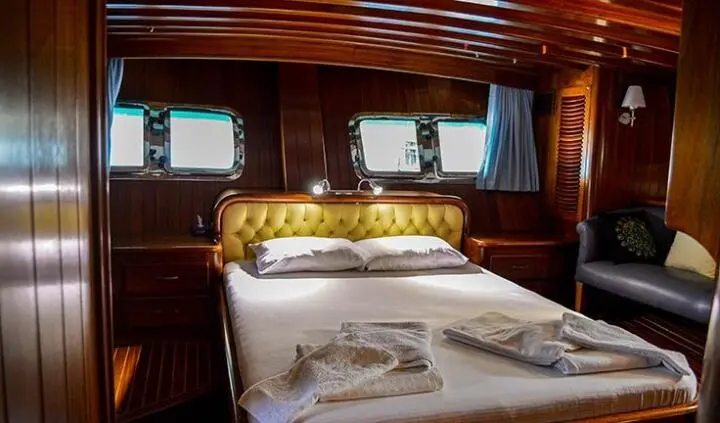 Two single beds with white bedding and wooden cabin interior
