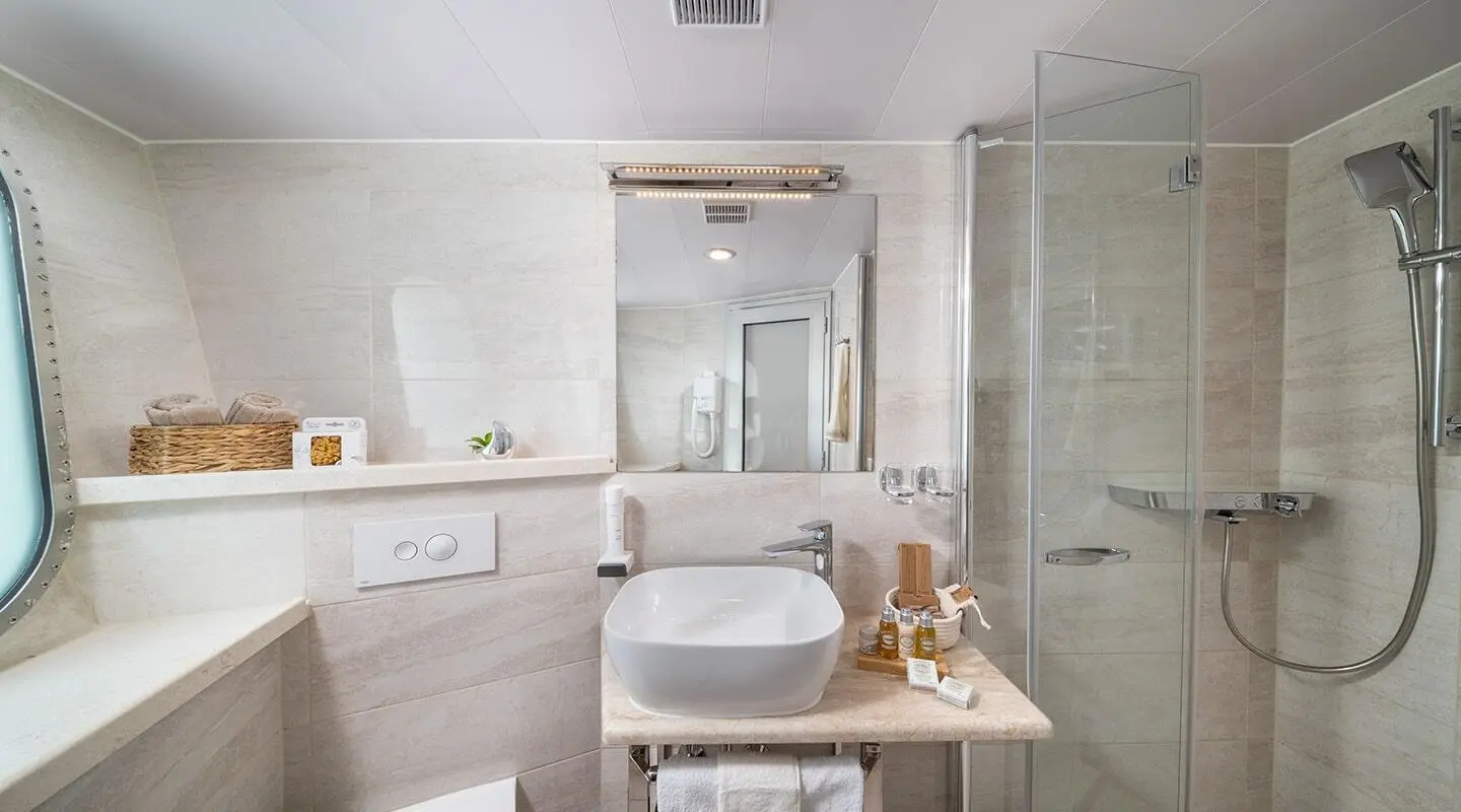Olimp yacht bathroom interior with sink, mirror, shower enclosure, and spa toiletries