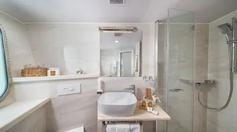 Olimp yacht bathroom interior with sink, mirror, shower enclosure, and spa toiletries