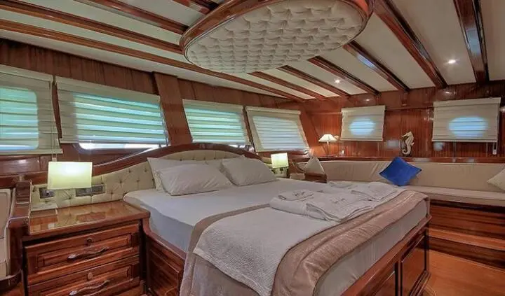 Lycian Queen master cabin with king bed, ensuite, wood panels, porthole windows