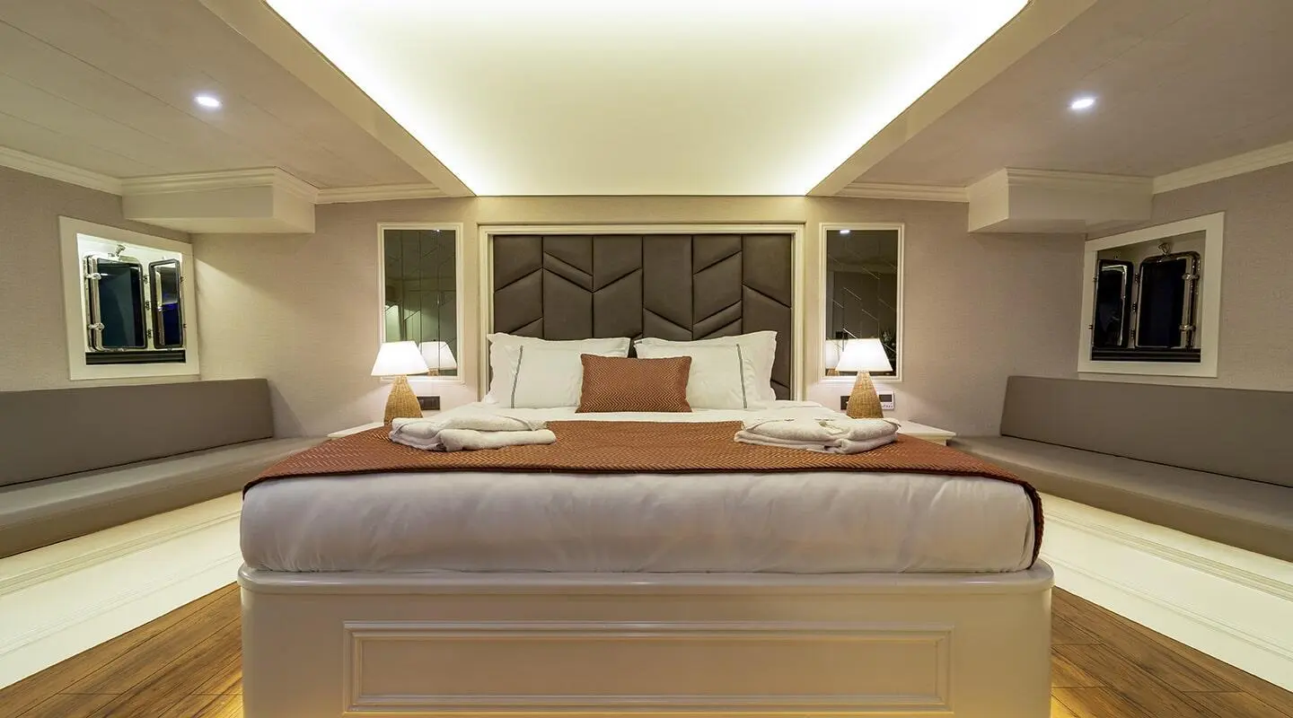 Queen Of Makri luxury gulet interior: spacious bed, ambient lighting, neutral tones