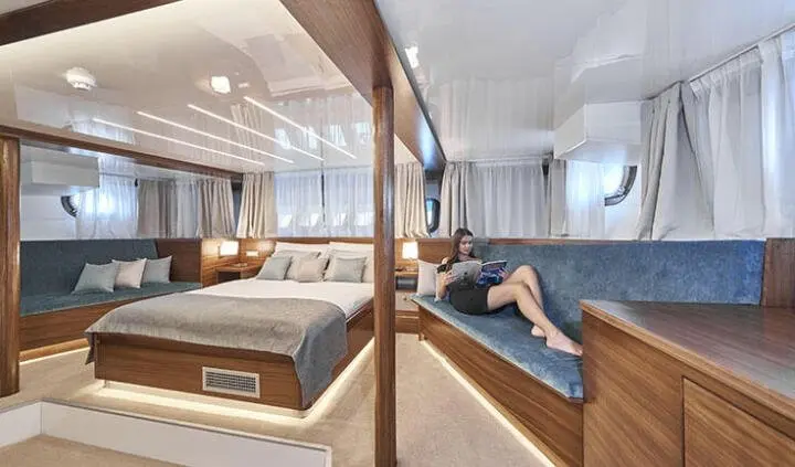 Master cabin with king bed, ensuite, wood paneling, windows, and seating