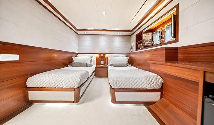 Interior of Alessandro I cabin with twin beds and wood accents, ensuites visible