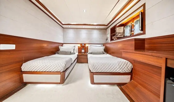 Interior of Alessandro I cabin with twin beds and wood accents, ensuites visible