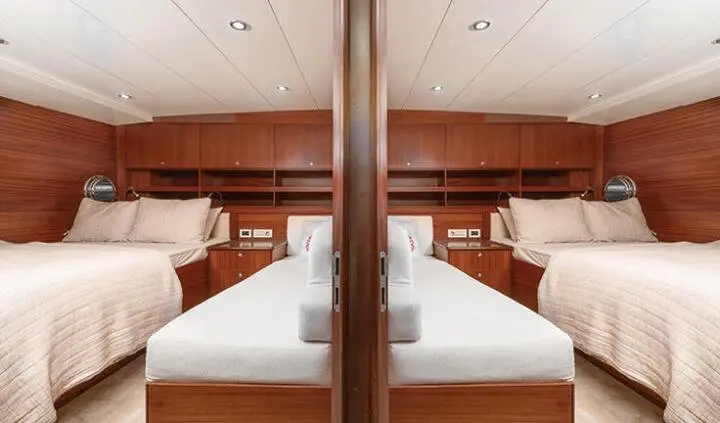 Twin-cabin luxury bed with two single beds separated by a central nightstand and wooden cabinetry