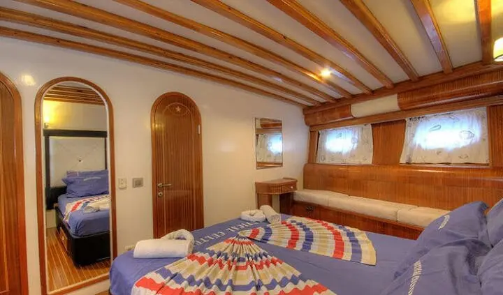 Angelo II master cabin with wooden beams and porthole window view