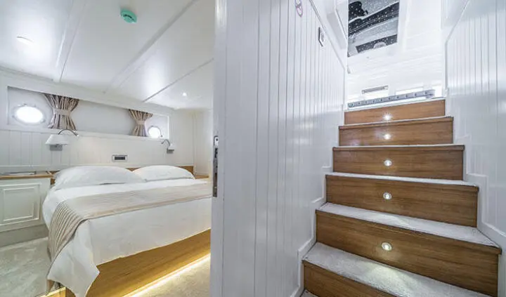 Master cabin with king bed, ensuite, soft lighting, wooden stairs nearby