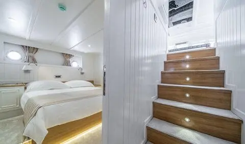 Master cabin with king bed, ensuite, soft lighting, wooden stairs nearby
