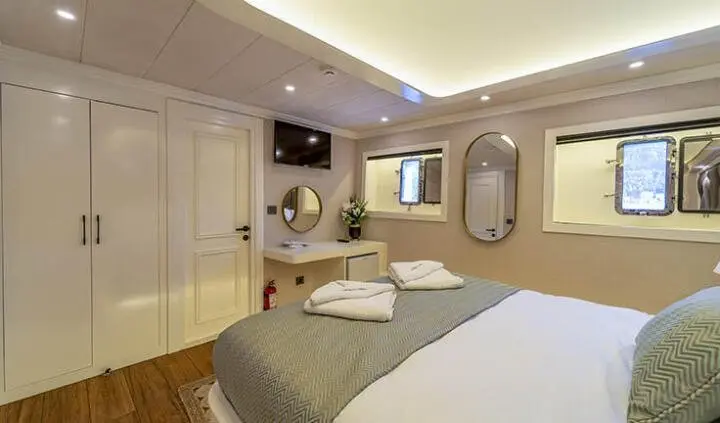 Queen Of Makri cabin with double bed, ensuite, warm lighting, wall mirror