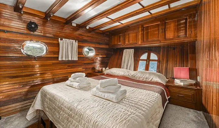 Cozy wooden cabin interior with two neatly made single beds and warm lighting