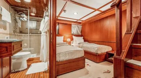 Interior of Seagull II yacht with a wooden cabin, bed, and seating area