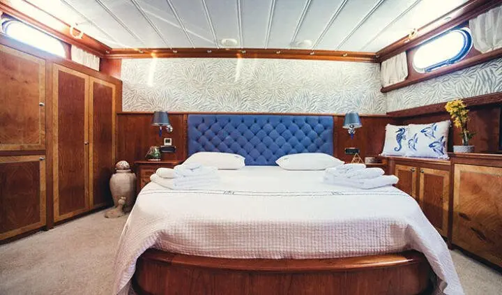 Luxurious yacht cabin with two large beds and wood accents, ambient lighting