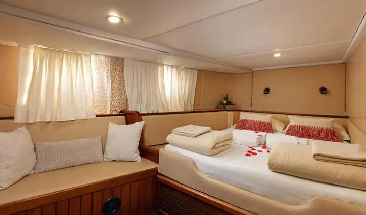 Two single beds with white linens and pink pillows in a cabin