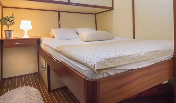 Duplex cabin bed on yacht Altair with two pillows and wood paneling