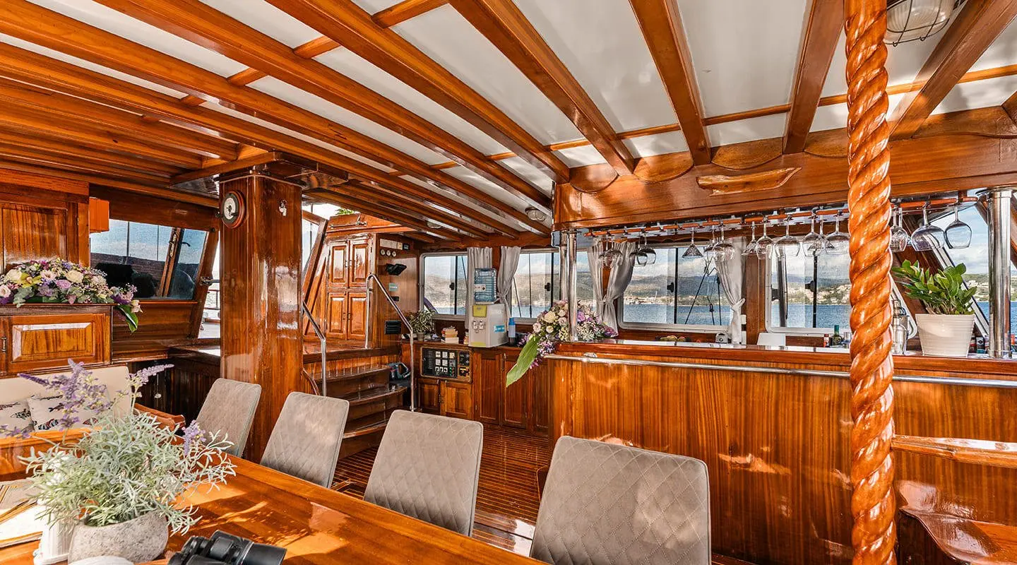 Luxurious wooden saloon on a Croatia gulet yacht with cushions and overhead beams