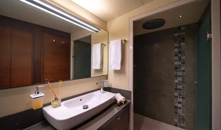 Double Eagle cabin bathroom with white sink, mirror, and beige tiles
