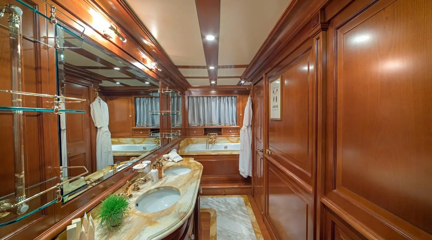 Interior of luxury Aquila yacht with wooden panels, dining table, and seating area