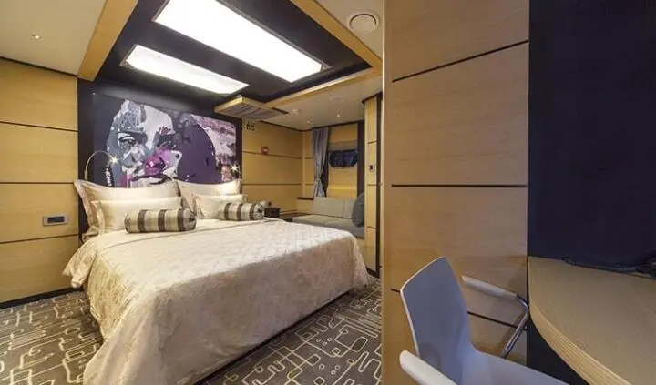 Navilux yacht cabin interior with king bed, cabinetry, and seating area