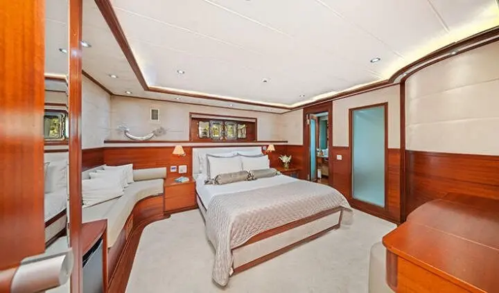 Master cabin with large bed, wooden cabinets, and ensuite door visible