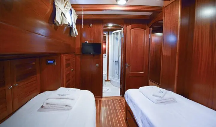 Ros Mare yacht twin cabin interior with wooden walls and two beds