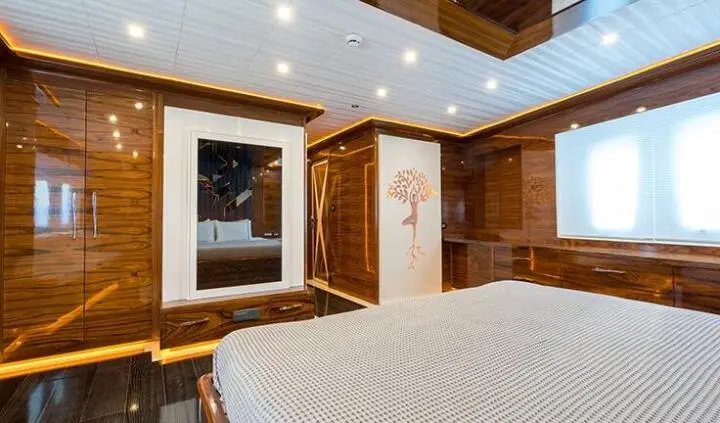 Master cabin with king bed, ensuite; wood panels and wardrobe visible