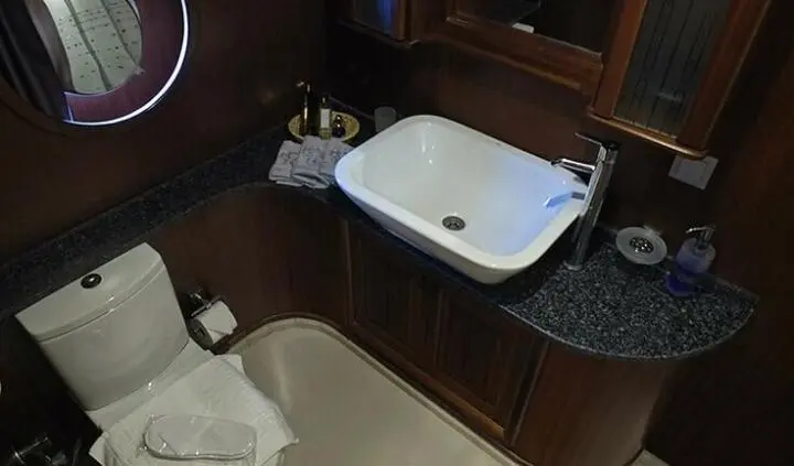 Small white bathtub in a dark wood bathroom with a countertop and sink