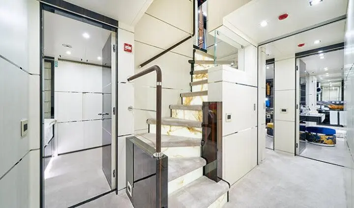 Master cabin with king bed, ensuite bathroom, and wooden staircase.