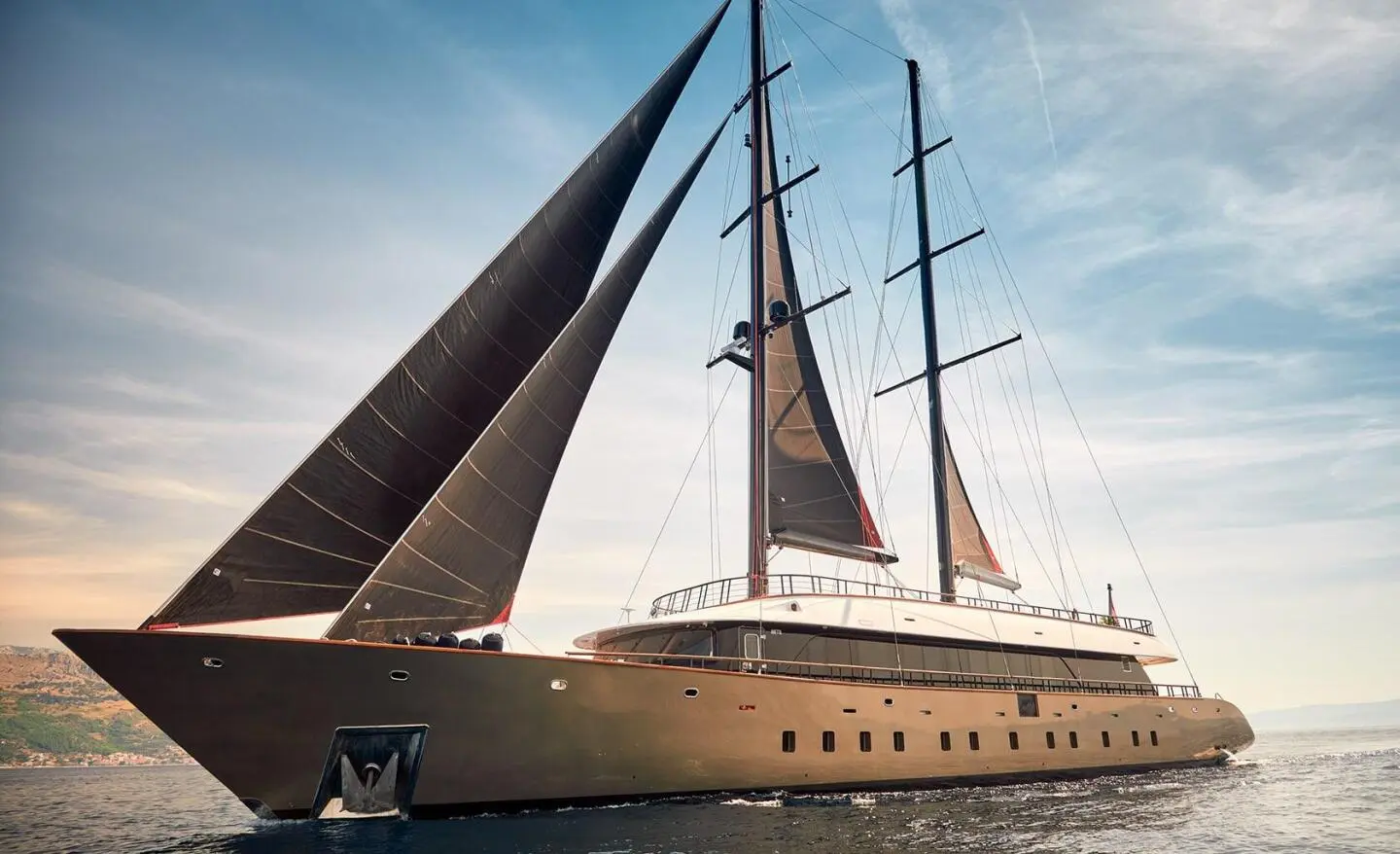 Yacht Anetta with tall masts and sails catching wind on blue sea