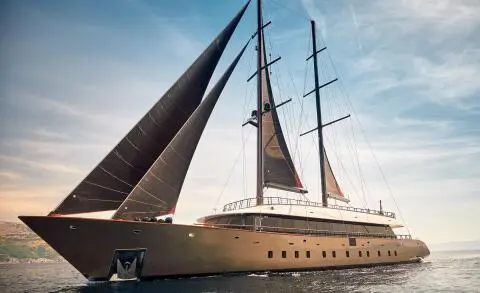 Yacht Anetta with tall masts and sails catching wind on blue sea