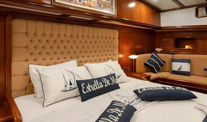 Estrella De Mar master cabin with king bed, tufted headboard, and pillows