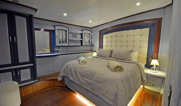 Bella Mare master cabin with king bed, tufted headboard, and ensuite glimpse