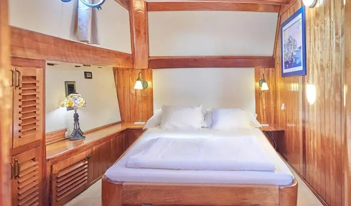 Cabin with king bed and ensuite; wood shelves and nightstands flank bed